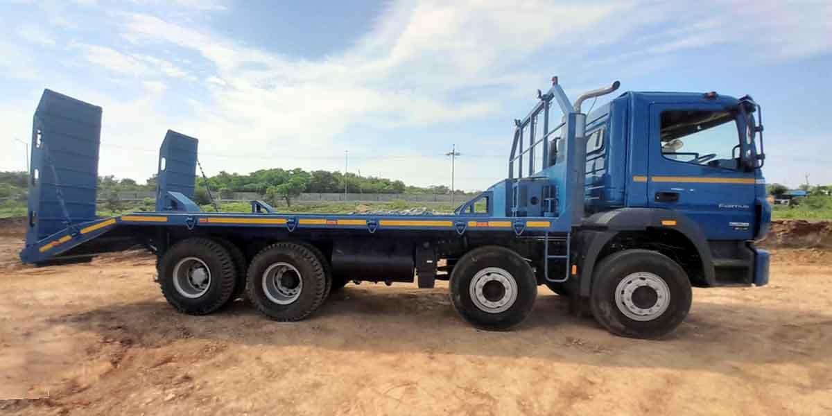 Blue flatbed truck with rear loading ramps