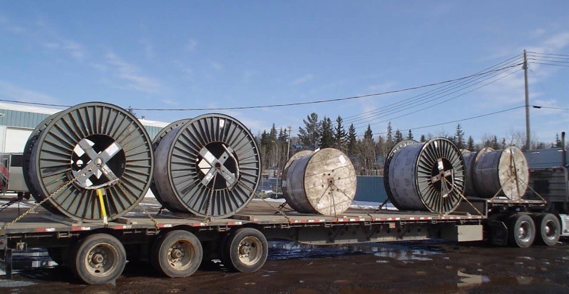 Flatbed trailer carrying large cable reels